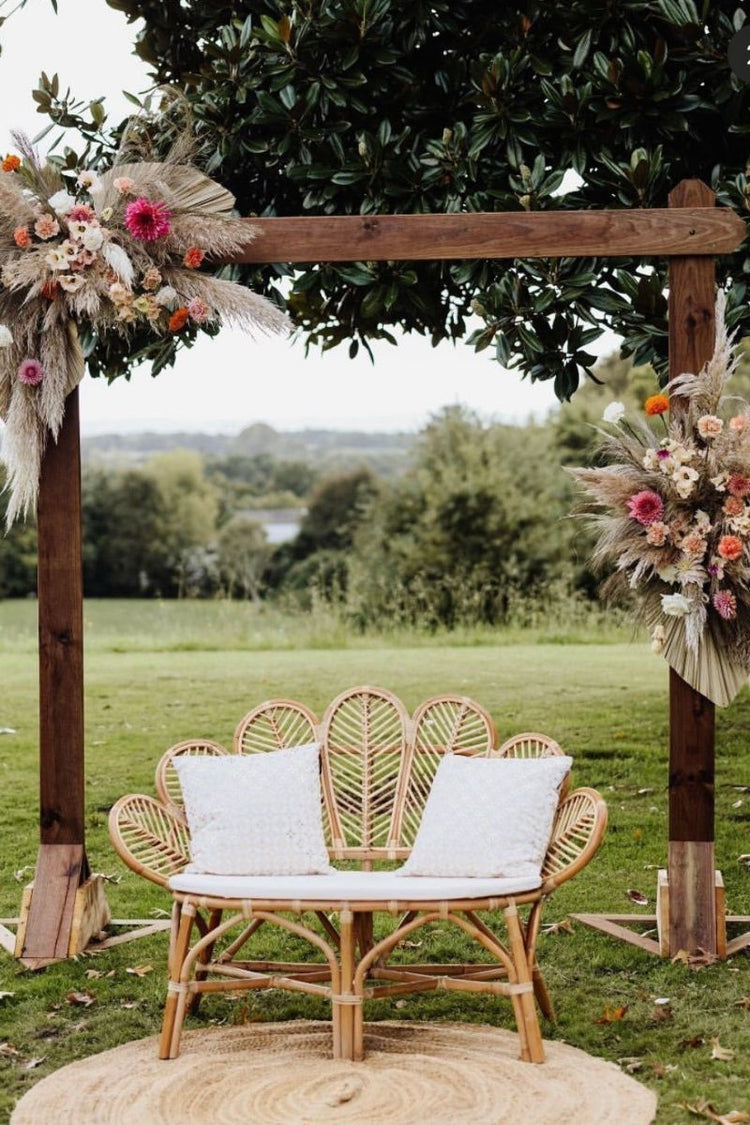 Banquette en rotin sous une arche pour un mariage