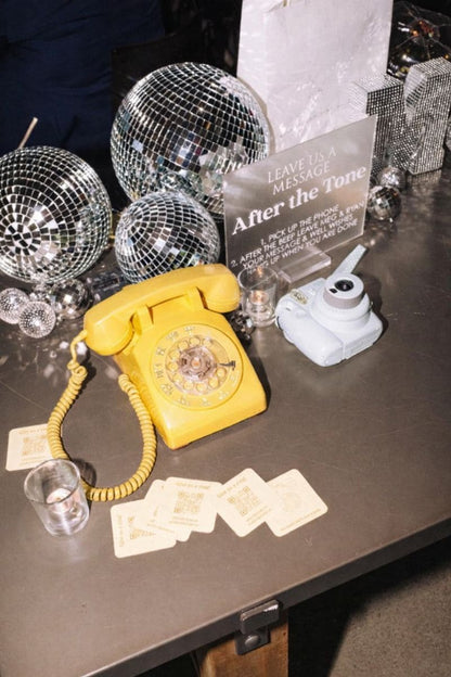 Livre d'or audio mariage jaune posé sur une table avec des boules à facettes